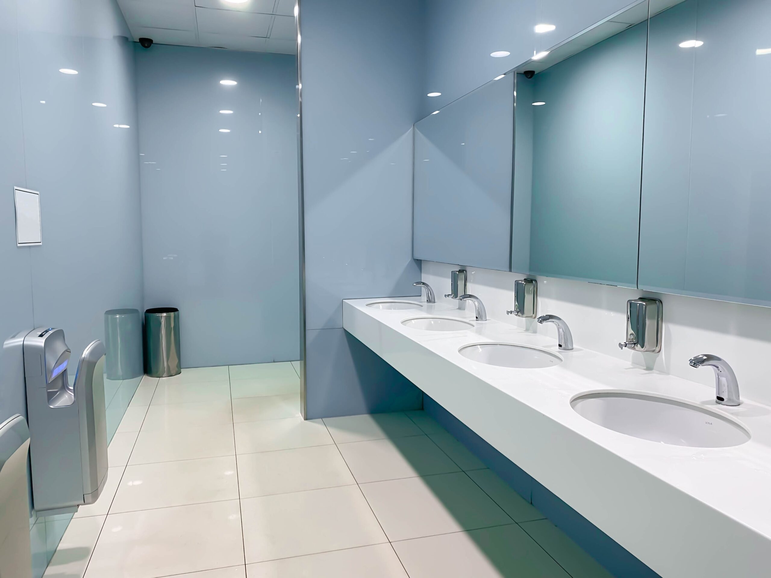 A beautiful and compliant ADA bathroom sink layout situated in a clean public restroom for guests and users.