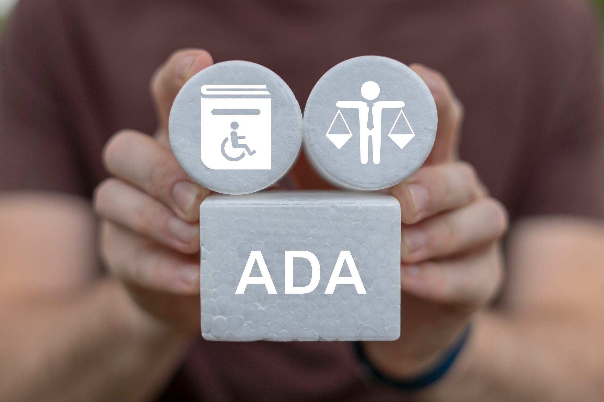 Small handicap bathroom designs and guidelines are illustrated by this man's hands as he holds up visual bathroom handicap-block visuals.